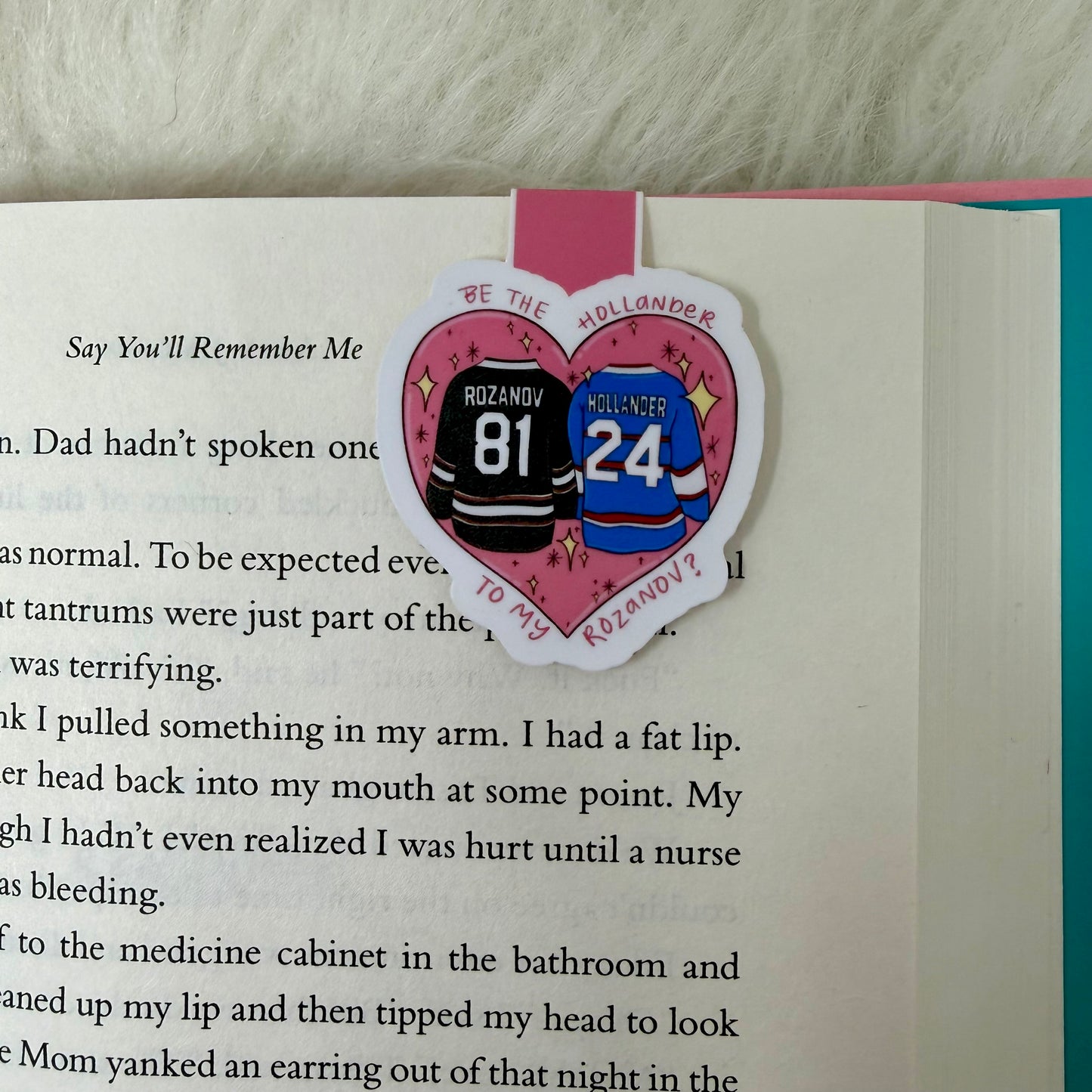 Heart-shaped bookmark with hockey player names and numbers on a book page