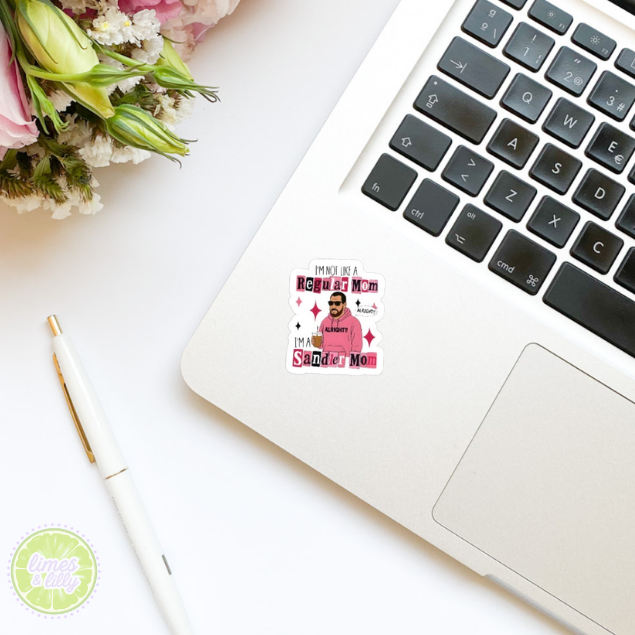Laptop with a sticker on a white surface with flowers and a pen.
