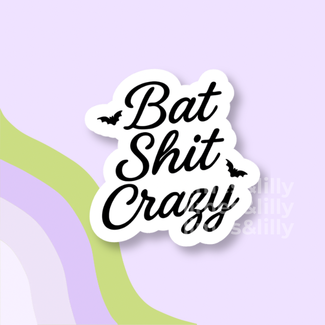 A die-cut vinyl sticker with the phrase 'Bat Shit Crazy' in black cursive script on a white background, accented with small black bat silhouettes. The sticker is displayed on a pastel purple background with abstract wavy stripes in light green and lavender.