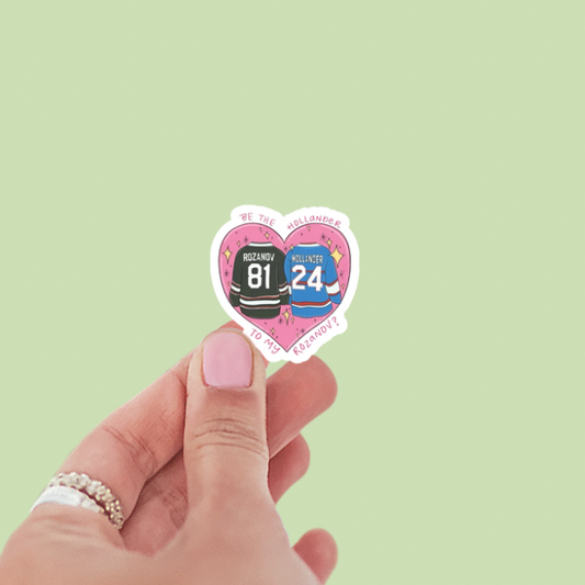 Heart-shaped sticker with hockey jerseys held by a hand on a light green background