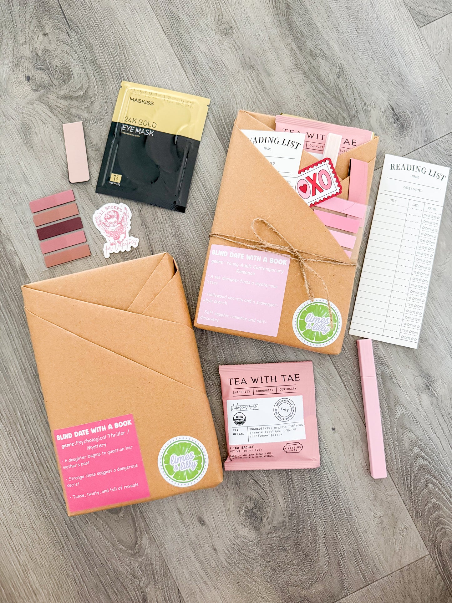 Collection of stationery items including notebooks, stickers, and a tea package on a wooden surface.