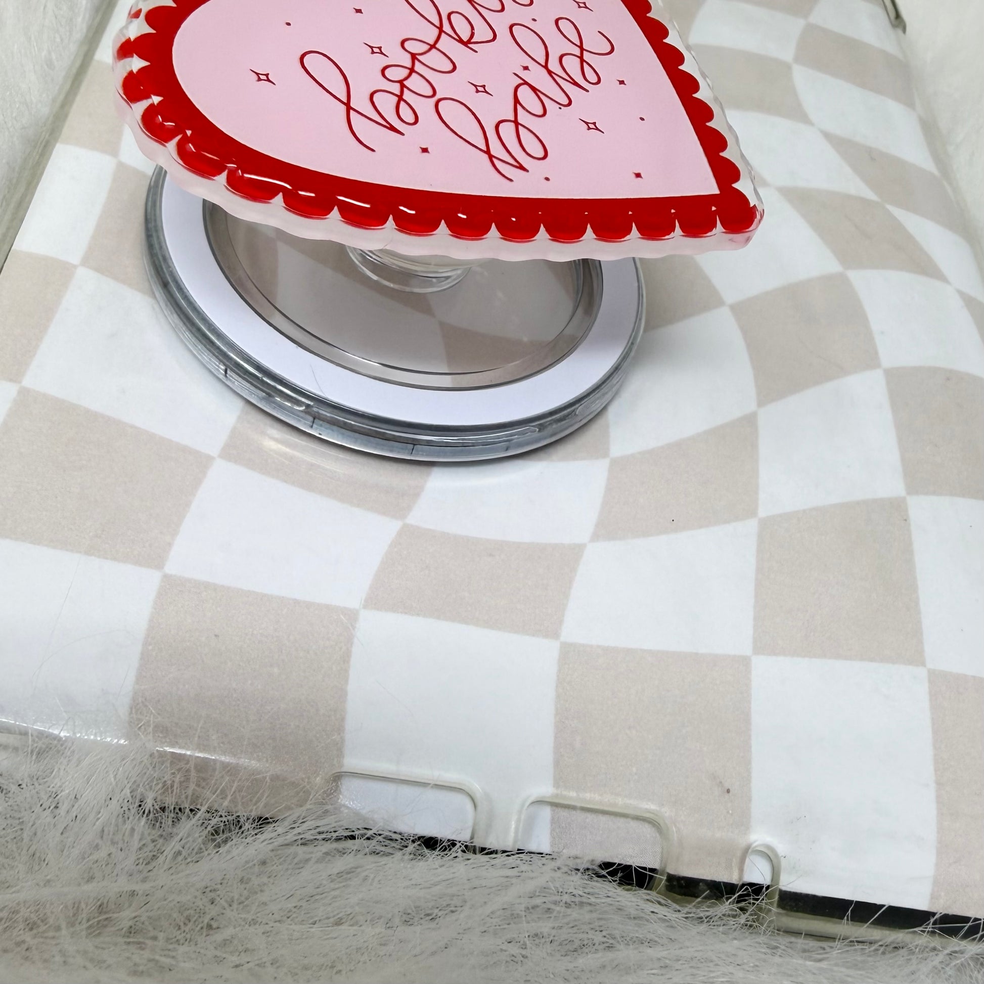 Heart-shaped glass with red and white design on a checkered tablecloth