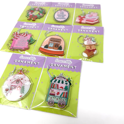 8 packaged Christmas ornament enamel pins arranged on a white background. Each pin is mounted on a bright green card with a purple header that reads 'lovely ORNAMENT.