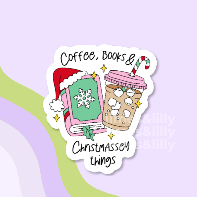 A die-cut sticker featuring a festive illustration with the text 'Coffee, Books & Christmas things.' The design shows a pink book with a green cover and Santa hat, next to a pink iced coffee cup with a candy cane straw, on a pastel lavender background.