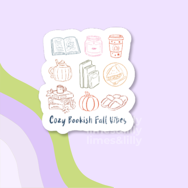 A die-cut sticker with the text 'Cozy Bookish Fall Vibes' and small illustrated autumn and book-themed icons, shown on a pastel lavender background with abstract green and lavender curved shapes.