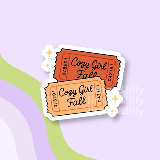 Two retro-style ticket stickers with scalloped edges, one orange-red and one peach-orange, featuring the text 'Cozy Girl Fall' and ticket numbers, shown on a pastel lavender background with abstract green and purple curved shapes.