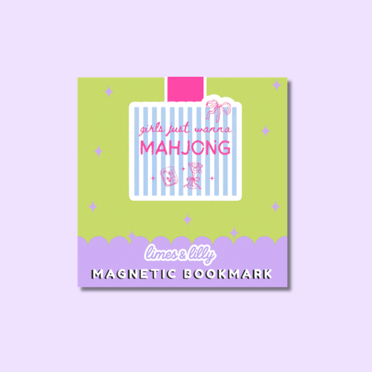 A square decorative magnetic bookmark card shown on a light lavender background. The card has a lime green top section with a central white label outlined in pink, pink text reading 'girls just want MAHJUNG', and a lavender bottom band with the words 'limes lilly' and 'MAGNETIC BOOKMARK'.