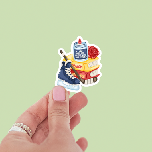 Sticker with books, boots, and a can held by a hand on a light green background