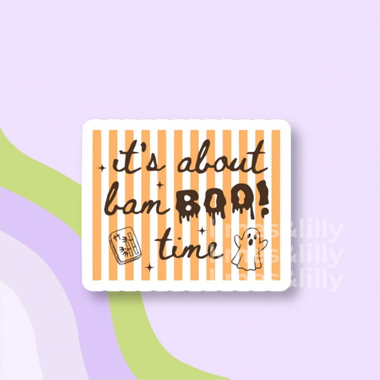 A rectangular sticker with rounded corners featuring orange and white vertical stripes, with the text 'it's about ban BOO! time' in dark brown lettering, accompanied by a small jack-o'-lantern and a ghost illustration. The sticker is displayed on a pastel purple background with abstract green and lavender curved shapes.