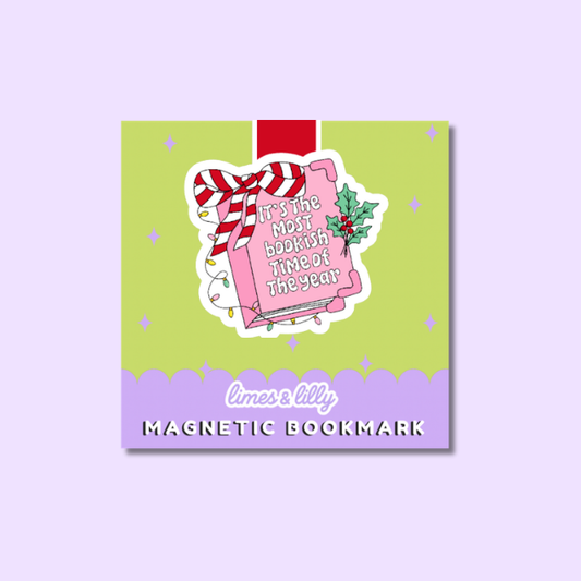 A square product card displaying a Christmas-themed magnetic bookmark. The card has a light green top section and a lavender bottom section with the text 'limes & lilly MAGNETIC BOOKMARK'.