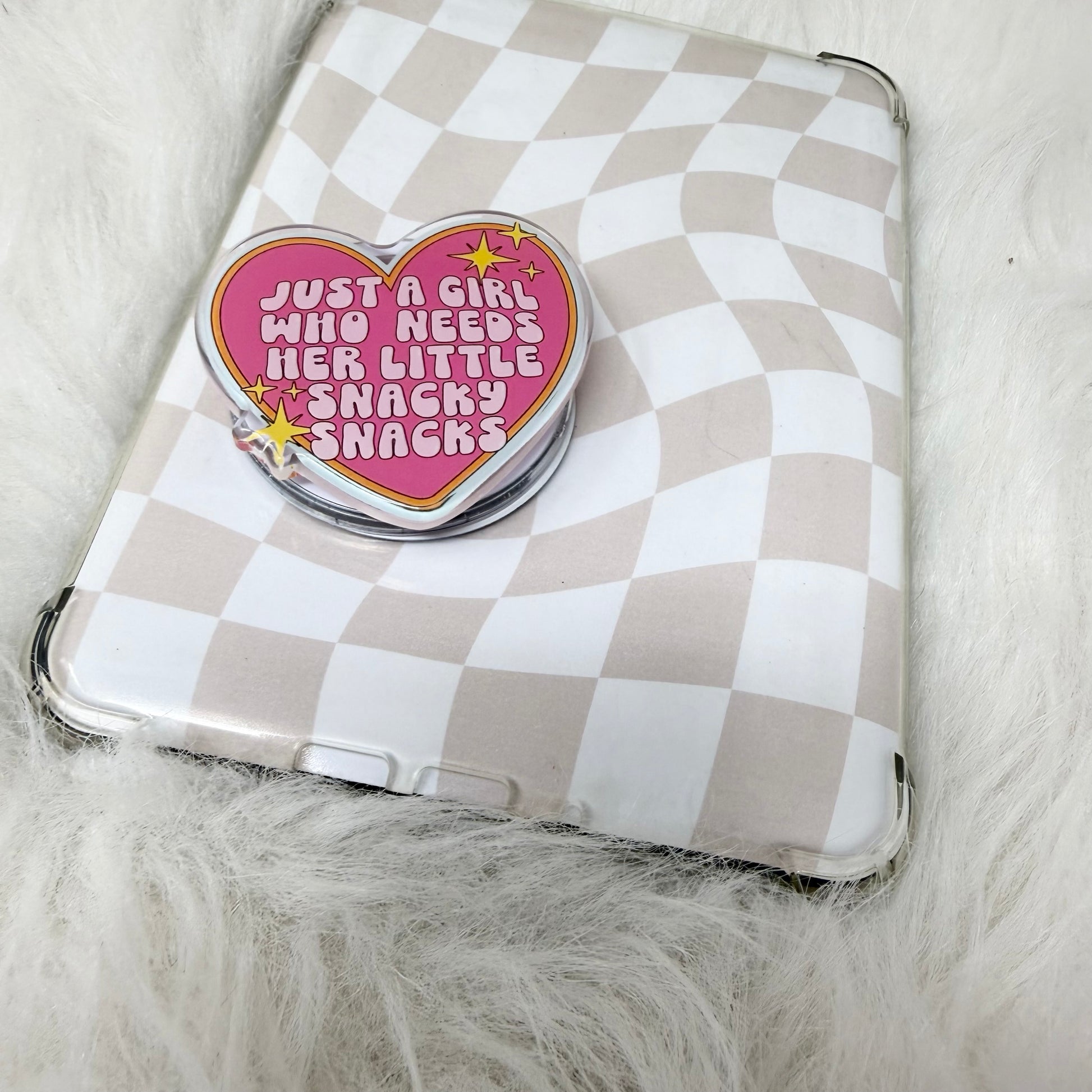 Checkered pouch with a heart-shaped pin on a fluffy surface