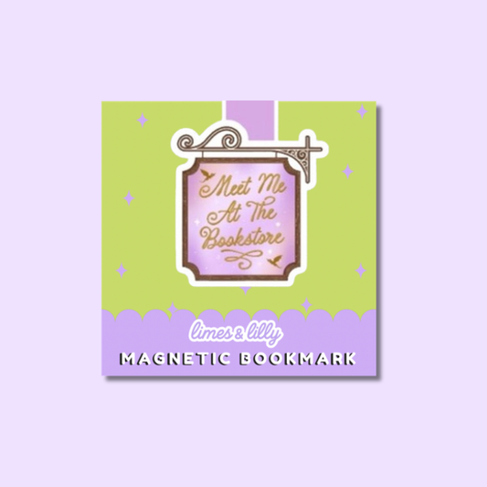 A square decorative magnetic bookmark card on a light lavender background. The card has a lime green upper section with small purple star accents, a central pink label reading 'Meet Me At The Bookstore' in gold script, and a purple lower band with the text 'limes & lilly' and 'MAGNETIC BOOKMARK'.