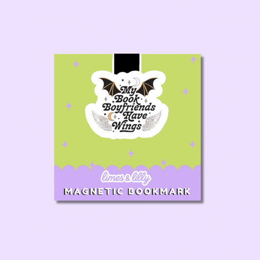 A square magnetic bookmark card with a lime green top half and lavender bottom border, featuring a white die-cut sticker that reads “My Book Boyfriends Have Wings” with bat and angel wings. The card is centered on a pale lavender background.