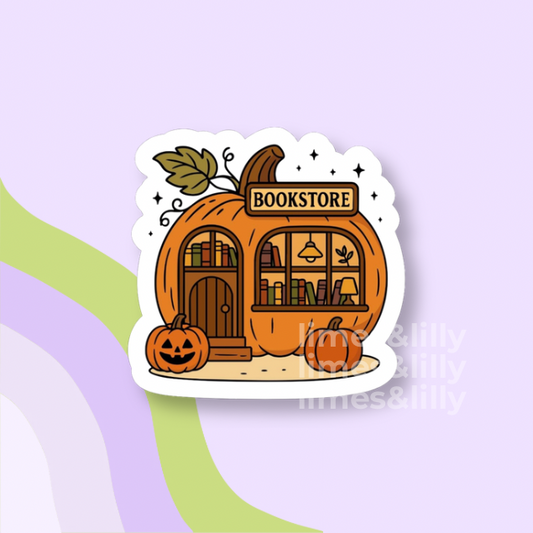 A die-cut sticker featuring a cute cartoon illustration of an orange pumpkin-shaped bookstore with a carved jack-o'-lantern in front, shown on a pastel lavender and green background.