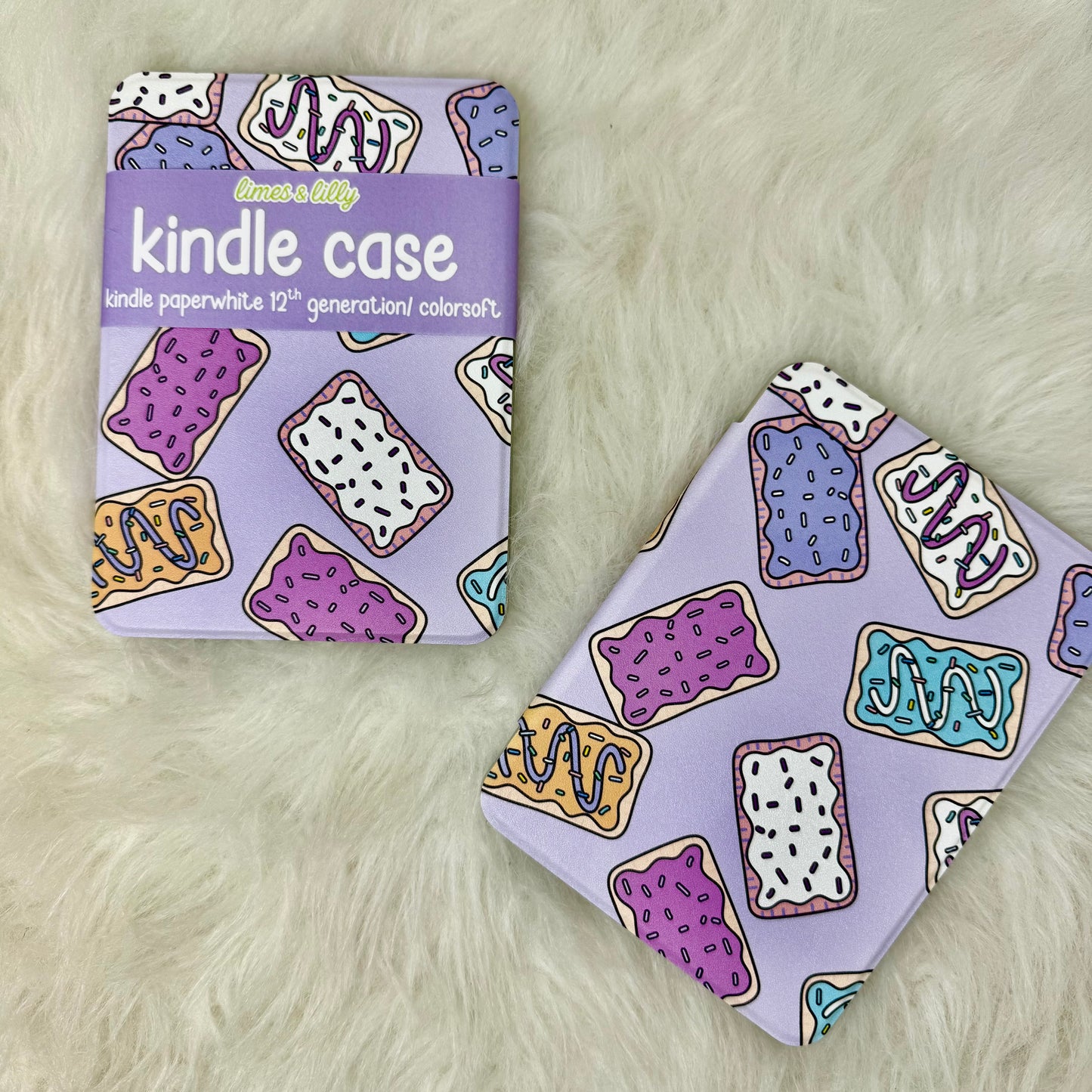 Kindle case with colorful donut pattern next to its packaging on a fluffy white surface
