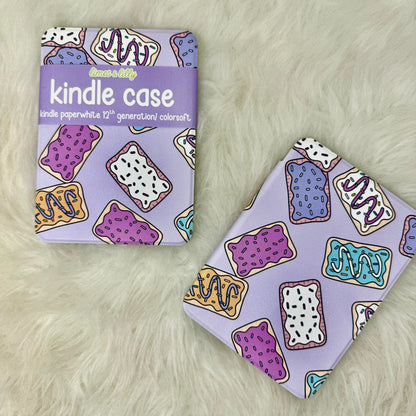 Kindle case with colorful donut pattern next to its packaging on a fluffy white surface