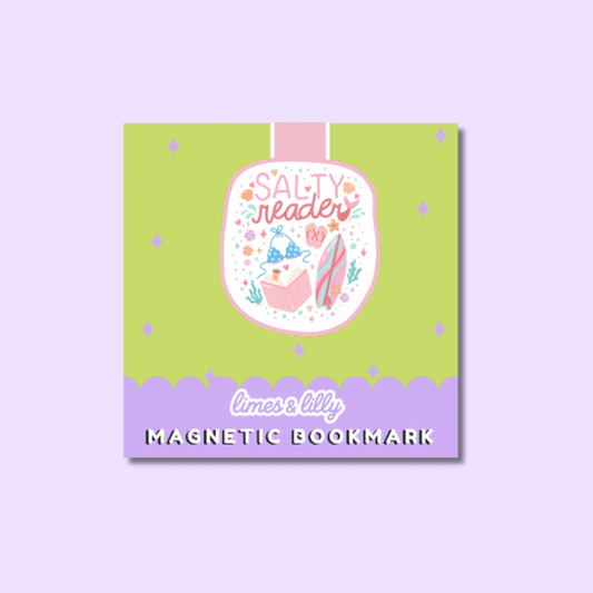 A square product card for a magnetic bookmark featuring a whimsical illustration. The card has a light green center with a pink and lavender scalloped bottom border, and a central illustration of a book character with the words 'SALTY reader'.