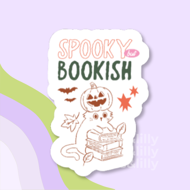 A die-cut sticker with a white background featuring a cute illustration of a cat reading books with a jack-o'-lantern head, plus the text 'SPOOKY but BOOKISH' in peach and dark green lettering. The sticker is centered on a pastel lavender background with abstract green and purple curved shapes.