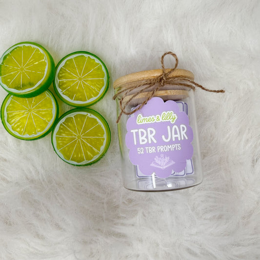 Clear jar labeled 'TBR Jar' with lime slices on a white background