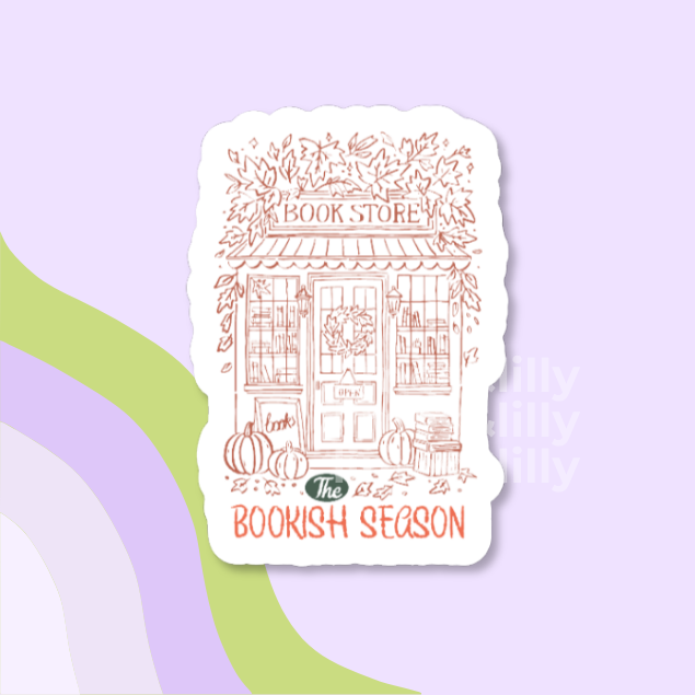 A die-cut sticker featuring a hand-drawn illustration of a book store storefront with pumpkins and autumn leaves, with the text 'The Bookish Season' on a light purple background with abstract green and lavender curved shapes.