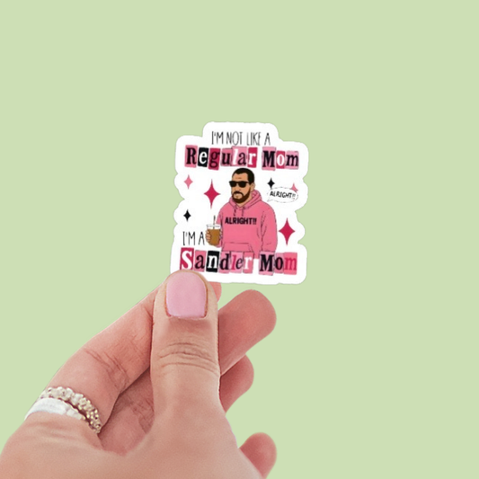 Hand holding a sticker with text and a graphic of a person, against a light green background